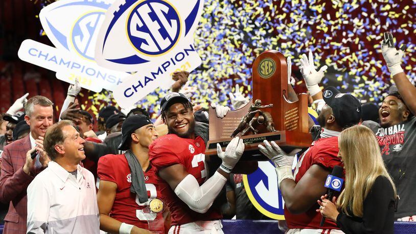 Alabama head coach Nick Saban (from left) looks on with MVP quarterback Bryce Young as Will Anderson and Phildarian Mathis lift the SEC Championship trophy after beating Georgia 41-24 on Saturday, Dec. 4, 2021, in Atlanta.   “Curtis Compton / Curtis.Compton@ajc.com”`