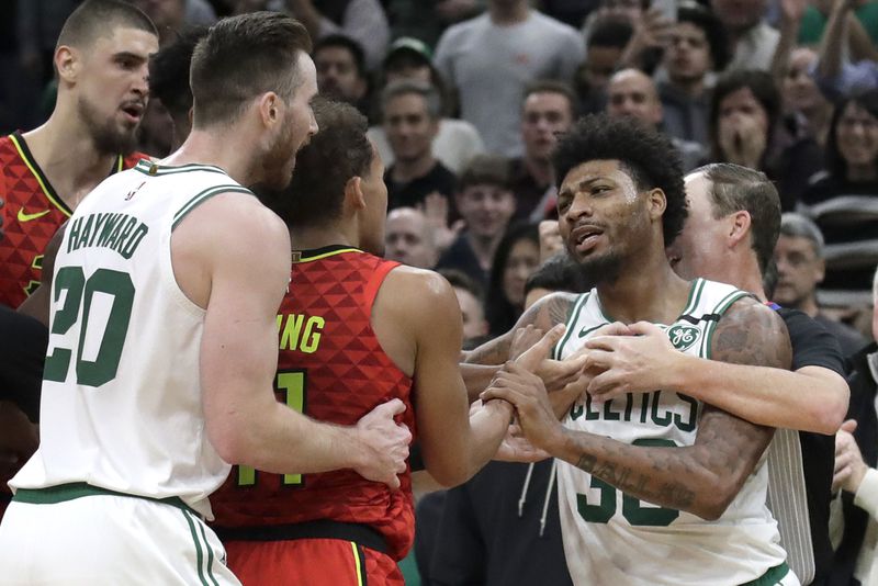 Boston Celtics guard Marcus Smart, right, is held back by a referee as Celtics forward Gordon Hayward (20) holds Hawks guard Trae Young (11) during a scuffle in the last seconds of an NBA basketball game Friday, Jan. 3, 2020, in Boston. The Celtics won 109-106. (AP Photo/Elise Amendola)