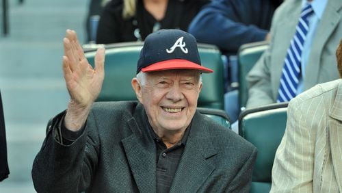 Former President Jimmy Carter waves to fans after he found a seat before the home opener against the Milwaukee Brewers at Turner Field in Atlanta on April 13, 2012.