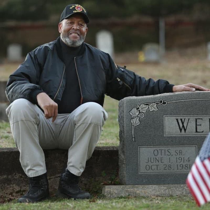 Kirk Canaday, a Johns Creek Historical Society member, sits beside a gravesite at historical Pleasant Hill Cemetery in Roswell. Photo courtesy Kirk Canaday