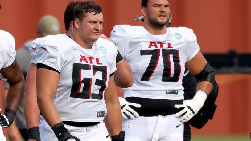 Falcons offensive guard Chris Lindstrom (63) and offensive tackle Jake Matthews (70) take a rest during training camp at the Falcons Practice Facility, Tuesday, August 2, 2022, in Flowery Branch, Ga. (Jason Getz / Jason.Getz@ajc.com)