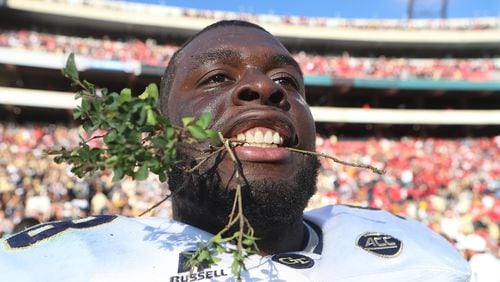 Georgia Tech center Freddie Burden takes a bite out of the hedges savoring a 28-27 victory over Georgia in a NCAA college football rivalry football game on Saturday, Nov. 26, 2016, in Athens. Curtis Compton/ccompton@ajc.com