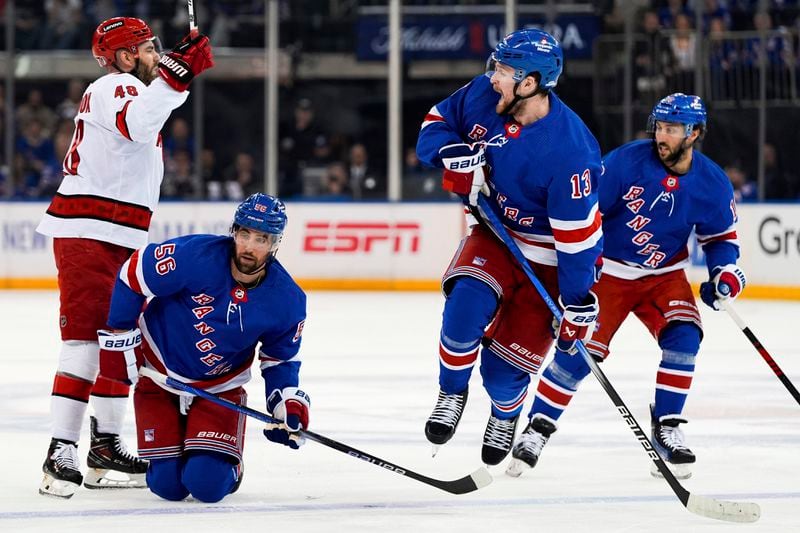New York Rangers left wing Alexis Lafrenière (13) jumps over defenseman Erik Gustafsson's (56) stick during the first period in Game 2 of an NHL hockey Stanley Cup second-round playoff series against the Carolina Hurricanes, Tuesday, May 7, 2024, in New York. (AP Photo/Julia Nikhinson)