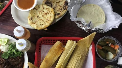 La Imperial Tortilleria y Rostiseria offers numerous tastes of Mexico, including (from top left) pupusas with salsa de tomate, fresh tortillas, pickled jalapenos, tamales and barbecued lamb. LIGAYA FIGUERAS / LFIGUERAS@AJC.COM