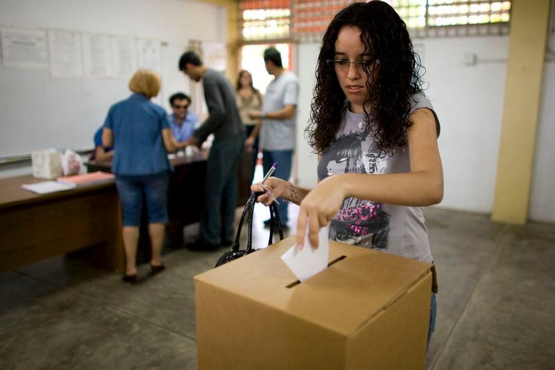 FILE- A woman votes in the Democratic primary election at a polling station in San Juan, Puerto Rico, June 1, 2008. Puerto Rico will hold a Democratic presidential primary Sunday, April 28, 2024, the only opportunity for Democrats on the island to officially weigh in on the race for the White House. Puerto Rico can't vote in the general election but may participate in presidential primaries and send delegates to both national conventions this summer. President Joe Biden has already unofficially clinched the nomination and faces minimal opposition on the ballot. (AP Photo/Brennan Linsley, File)