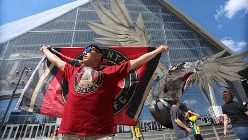 Manuel Garcia from Asheville North Carolina, shows he’s support with the Atlanta United flag in front of the eagle outside of the Mercedes-Benz Stadium on April 28, 2018.