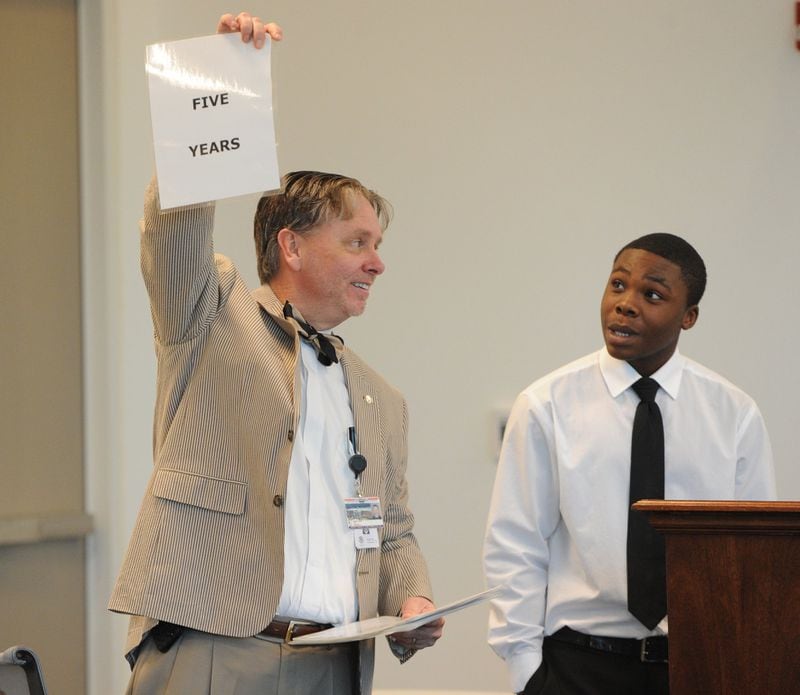 Judge Steven Teske of Clayton County Juvenile Court holds up a piece of paper bearing the words “Five Years” during his Second Chance program on February 26, 2012. Looking on is Quantavious Poole, who completed the program. Five years is how much prison time awaits program graduates if they make another criminal choice in life. (Johnny Crawford / AJC file)