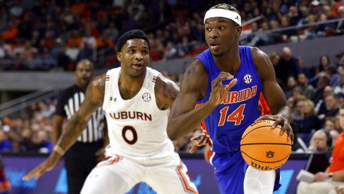 Florida guard Kowacie Reeves (14) drives to the basket around Auburn guard K.D. Johnson (0) during the first half of an NCAA basketball game Wednesday, Dec. 28, 2022, in Auburn, Ala. (AP Photo/Butch Dill)