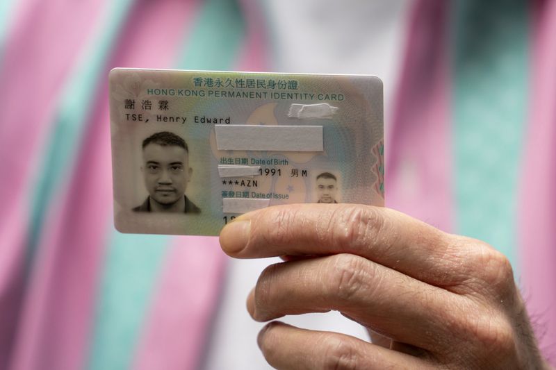 Activist Henry Tse, who won an appeal to change the gender on his ID card, shows his ID to the press after receiving the new document in Hong Kong, Monday, April. 29, 2024. The Hong Kong transgender activist who fought a years-long legal battle to change the gender on his official identity card finally received the new document on Monday, vowing to continue working hard on the unfinished path of fighting for equality for his community. (AP Photo/Vernon Yuen)