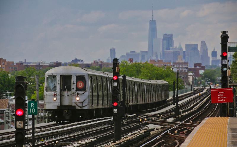 FILE - A subway approaches an above ground station in the Brooklyn borough of New York with the New York City skyline in the background, June 21, 2017. New Jersey is incentivizing taxpayers who work from home for New York based employers to sue New York in court for taxing their wages. (AP Photo/Bebeto Matthews, File)