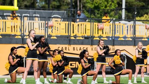Five KSU cheerleaders take a knee during the national anthem prior to the matchup between Kennesaw State and North Greenville, Saturday, Sept. 30, 2017. (Special to AJC/by Cory Hancock)
