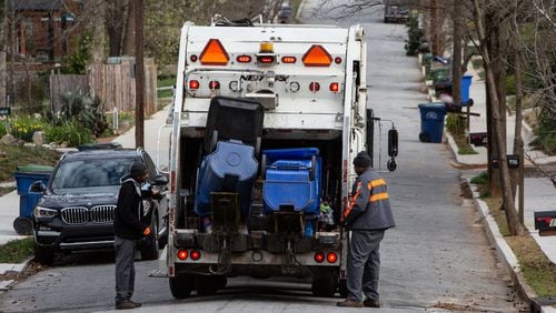 Department of Public Works employees pick up recycling bins in the city of Atlanta in 2019. CONTRIBUTED BY PHIL SKINNER