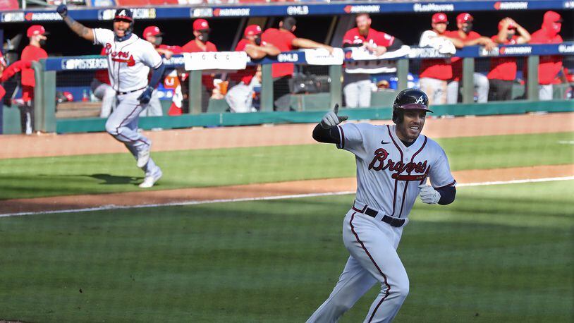 Braves pinch-runner Cristian Pache (background) heads home to score on Freddie Freeman's bloop single in the 13th inning of Game 1 of the wild card playoff series against the Cincinnati Reds Wednesday, Sept. 30, 2020, at Truist Park in Atlanta.