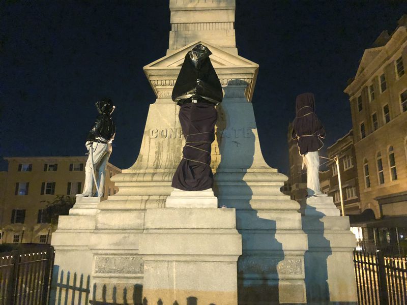 A Confederate monument is covered in sheets and bags early Wednesday in downtown Portsmouth, Virginia. 
