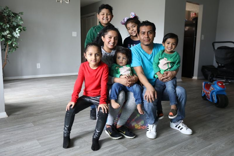 The Hernandez family at their new apartment, which they recently moved into and have not yet furnished. (Photo: Miguel Martinez for the AJC)