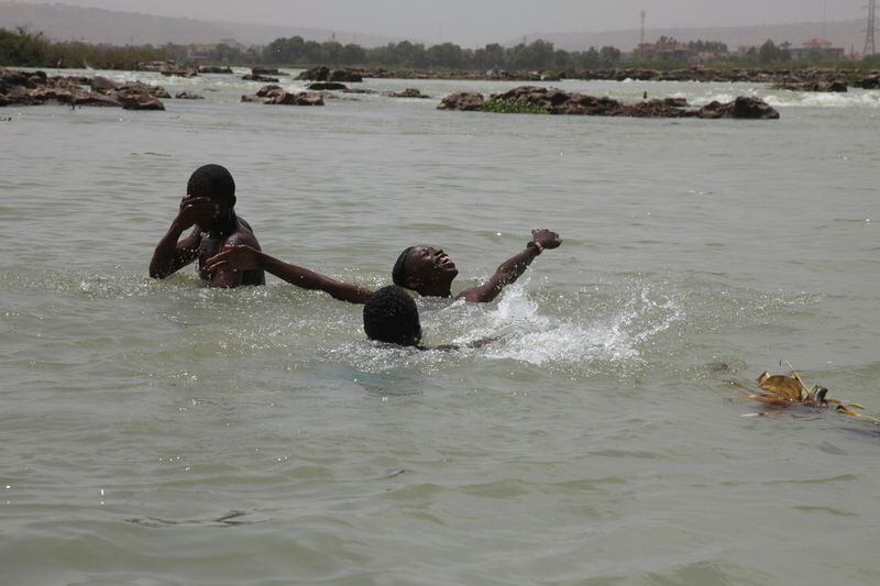 Children play inside a river to cool off from a blazing sun in Bamako, Mali, Thursday, April, 18, 2024. On Thursday, temperatures in Bamako reached 44 degrees Celsius (111 Fahrenheit) and weather forecasts say it's not letting up anytime soon. (AP Photo/Baba Ahmed)