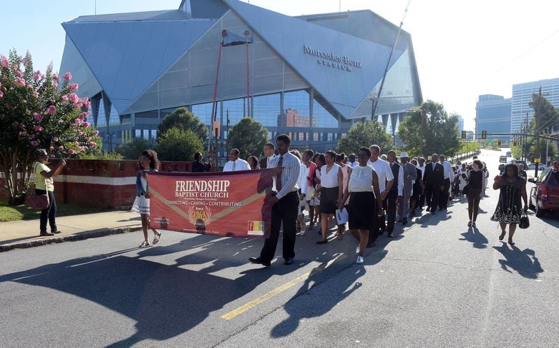 JULY 30, 2017 ATLANTA Members march from the site of the old church to the new to attend the first morning worship service at Friendship Baptist Church Sunday, July 30, 2017. The 155-year old historic church, which started out as the home for both Morehouse and Spelman Colleges, was rebuilt after their former building was demolished to make way for the Falcons' Mercedes-Benz Stadium. KENT D. JOHNSON / AJC