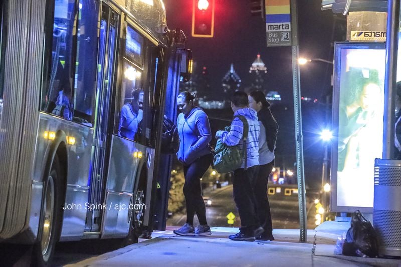 MARTA patrons board a bus at a stop on Buford Highway at North Cliff Valley Way, where a man ran from across the street to hail a bus overnight. He was killed when he was caught underneath its wheel. JOHN SPINK / JSPINK@AJC.COM