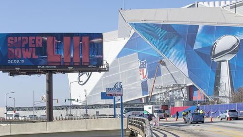 Workers  wrap parts of Mercedes-Benz Stadium with Super Bowl LIII graphics.