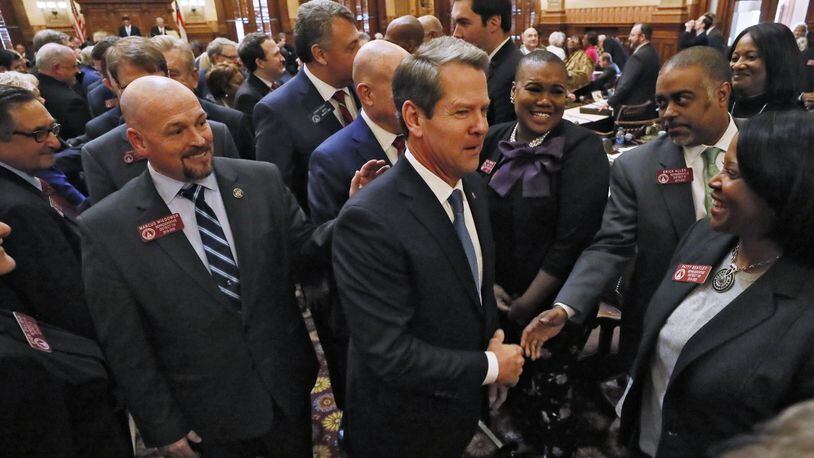 Gov. Brian Kemp shakes hands with lawmakers as he departs the House after he delivered his first State of the State address. BOB ANDRES /BANDRES@AJC.COM