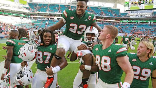 Miami Hurricanes tight end Christopher Herndon IV (23) is carried off by teammates after the University of Miami Hurricanes defeated the Virginia  Cavaliers at Hard Rock Stadium on Saturday, Nov. 18, 2017 in Miami. The Hurricanes won 44-28. (Al Diaz/Miami Herald/TNS)