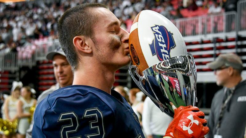 Eagle's Landing Christian Academy linebacker Michael Meneely kisses the championship trophy.