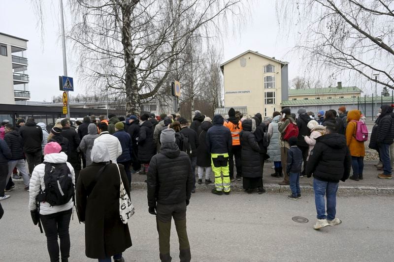 Family members of pupils of the Viertola comprehensive school wait to enter the school, in Vantaa, Finland, Tuesday, April 2, 2024. A 12-year-old student opened fire at a secondary school in southern Finland on Tuesday morning, killing one and seriously wounded two other students, police said. The suspect was later arrested. (Markku Ulander/Lehtikuva via AP)