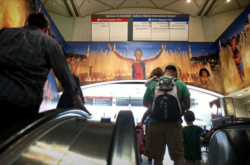 April 23, 2013 - Atlanta, Ga: After traveling on the automated people movers, paassengers travel up the long escalator where the well-known mural welcomes visitors to Atlanta at Hartsfield-Jackson Atlanta International Airport Tuesday morning in Atlanta, Ga., April 23, 2013. Nearly a year after the Atlanta airport opened its new international terminal, it is already planning for the next expansion. Hartsfield-Jackson International Airport's master plan study shows the airport will soon need more parking, and will also need more people-mover train capacity inside the terminal, more security screening line space, more gates and more airfield capacity - such as another runway -- in the next 20 years JASON GETZ / JGETZ@AJC.COM