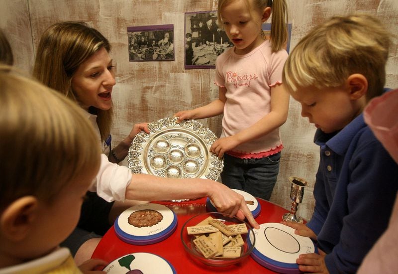 Passover Seder meals won’t be the same this year, especially for those who usually gather extended family for the event. In this 2008 file photo, Cyndi Sterne (left) teaches children from a home school group out of Perimeter Church about Passover Seder dinner during a tour of the Sophie Hirsh Srochi Discovery Center at the Marcus Jewish Community Center of Atlanta. AJC FILE