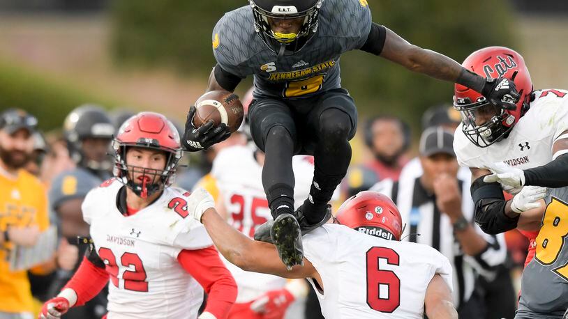 Kennesaw State running back Iaan Cousin (3) of Mount Zion High in Carroll County goes airborne over the Davidson Wildcat defense in the fourth quarter during a first-round FCS playoff game Saturday, Nov. 27, 2021 at Fifth Third Bank Stadium. Cousin is one of more than 70 Georgia players on Kennesaw Mountain's roster. Kennesaw Mountain started football in 2015. (Daniel Varnado/ For the Atlanta Journal-Constitution)