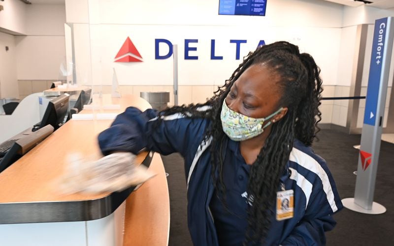 A cleaning crew wipes down a Delta Air Lines counter at Hartsfield-Jackson International Airport in Atlanta on Thursday, July 2, 2020. (Hyosub Shin / Hyosub.Shin@ajc.com)