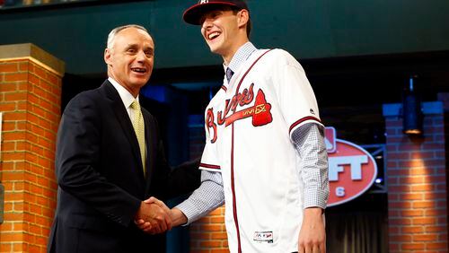 Commissioner Rob Manfred, left, shakes hands with Ian Anderson, a pitcher from Shenendehowa High School in Clifton Park, N.Y., after Anderson was drafted No. 3 by the Atlanta Braves in the first round of the Major League Baseball draft, Thursday, June 9, 2016, in Secaucus, N.J. (AP Photo/Julio Cortez)