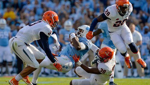 CHAPEL HILL, NC - OCTOBER 24: Quin Blanding #3 and Kelvin Rainey #38 of the Virginia Cavaliers tackle Marquise Williams #12 of the North Carolina Tar Heels during their game at Kenan Stadium on October 24, 2015 in Chapel Hill, North Carolina. (Photo by Grant Halverson/Getty Images)