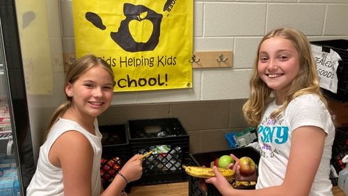 Students, from left, Kate and Addy count and sort uneaten fruit from the cafeteria at Kelly Mill Elementary School in Forsyth County. The food will be donated to local food pantries. Courtesy of Kelly Mill Elementary School.