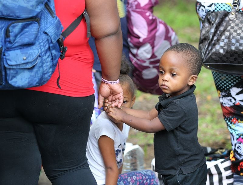 September 9, 2017 Savannah: A child holds his mother's hand waiting in line as hundreds of local residents are evacuated from the city at the Savannah Civic Center during a mandatory evacuation on Saturday, September 9, 2017, in Savannah. Officials are expecting 1,500 to 3,000 without transportation to board buses being provided at the location.  Curtis Compton/ccompton@ajc.com