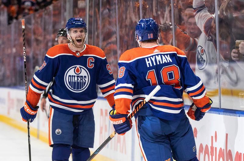 Edmonton Oilers' Connor McDavid (97) and Zach Hyman (18) celebrate a goal against the Los Angeles Kings during the second period of Game 2 of an NHL hockey Stanley Cup first-round playoff series Wednesday, April 24, 2024, in Edmonton, Alberta. (Jason Franson/The Canadian Press via AP)