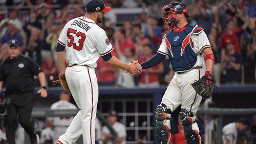 Braves closer Jim Johnson catcher Tyler Flowers shake hands after the Braves home-opening win Friday against the Padres. (HYOSUB SHIN / HSHIN@AJC.COM)