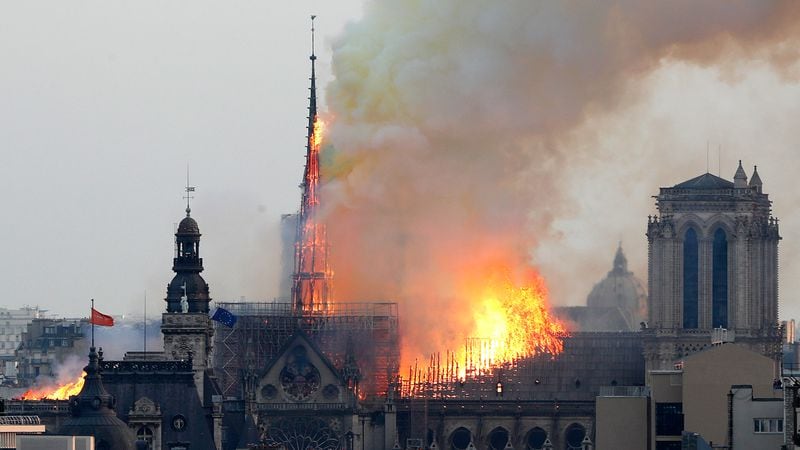 Flames rise from Notre Dame cathedral as it burns in Paris, Monday, April 15, 2019. Massive plumes of yellow brown smoke is filling the air above Notre Dame Cathedral and ash is falling on tourists and others around the island that marks the center of Paris.