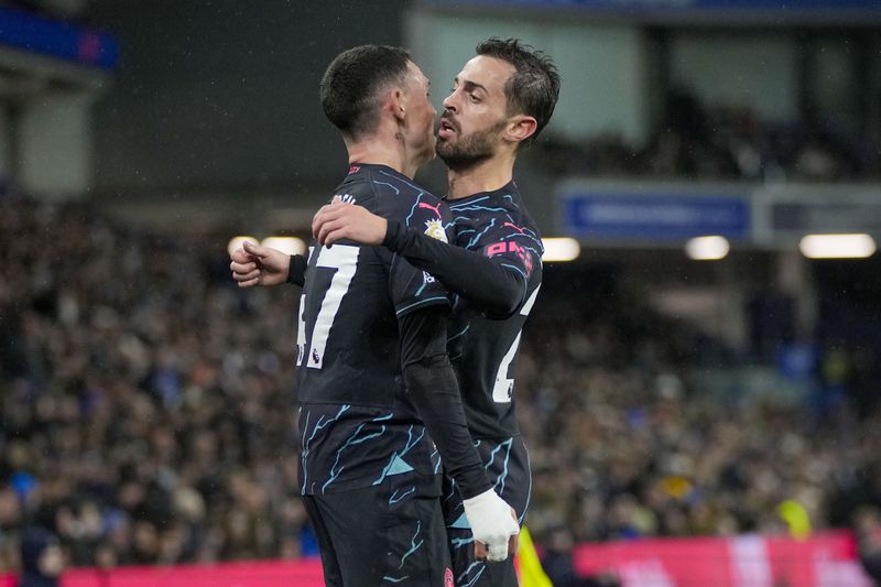 Manchester City's Phil Foden, left, celebrates with Manchester City's Bernardo Silva after scoring his side's third goal during the English Premier League soccer match between Brighton and Manchester City at the Falmer Stadium in Brighton, England, Thursday, April 25, 2024. (AP Photo/Kin Cheung)