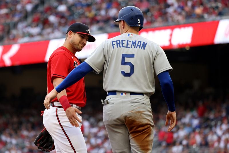 Braves third baseman Austin Riley, left, greets Los Angeles Dodgers first baseman Freddie Freeman (5) as Freeman advanced to third base during the first inning at Truist Park Friday, June 24, 2022, in Atlanta. (Jason Getz / Jason.Getz@ajc.com)