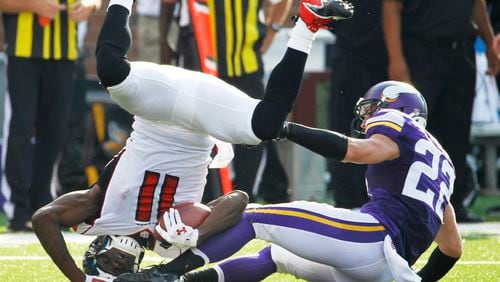 Atlanta Falcons wide receiver Julio Jones (11) is tackled by Minnesota Vikings free safety Harrison Smith during the first half of an NFL football game, Sunday, Sept. 28, 2014, in Minneapolis. (AP Photo/Ann Heisenfelt)