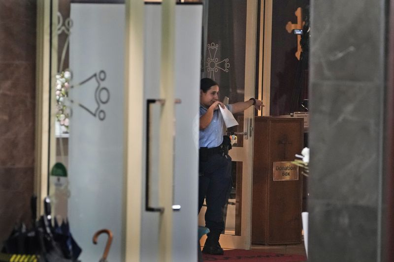 A police officer investigates in a church where a bishop and churchgoers were reportedly stabbed in Sydney Australia, Monday, April 15, 2024. Police in Australia say a man has been arrested after a bishop and churchgoers were stabbed in the church. There are no life-threatening injuries. (AP Photo/Mark Baker)