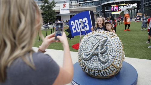 Chelsea Wood takes a cellphone photo to Kate and Brooks Wood by the World Series Championship ring outside the Chop House gate by The Battery Atlanta moments before the game between the Atlanta Braves and the Chicago Cubs at Truist Park on Wednesday, Sep. 27, 2023, in Atlanta. 
Miguel Martinez / miguel.martinezjimenez@ajc.com
