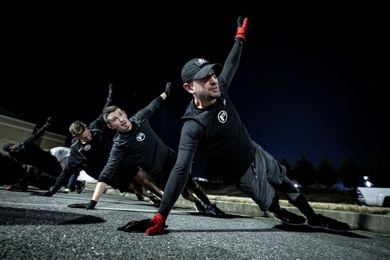 Members of the F3 men's exercise group in Cherokee County practice some pre-dawn plank exercises. Daniel Andretta began meeting with the group every week day after COVID-19 hit the U.S. in a bid to get healthier. He's lost about 50 pounds in the year since he joined.