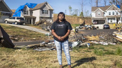 Brittany Mitchell, 30, stands in front of her home, where a tornado ripped through her neighborhood in late March. Mitchell crouched in a hallway closet, using her body to shield her two young daughters alongside her husband. (Alyssa Pointer / Alyssa.Pointer@ajc.com)