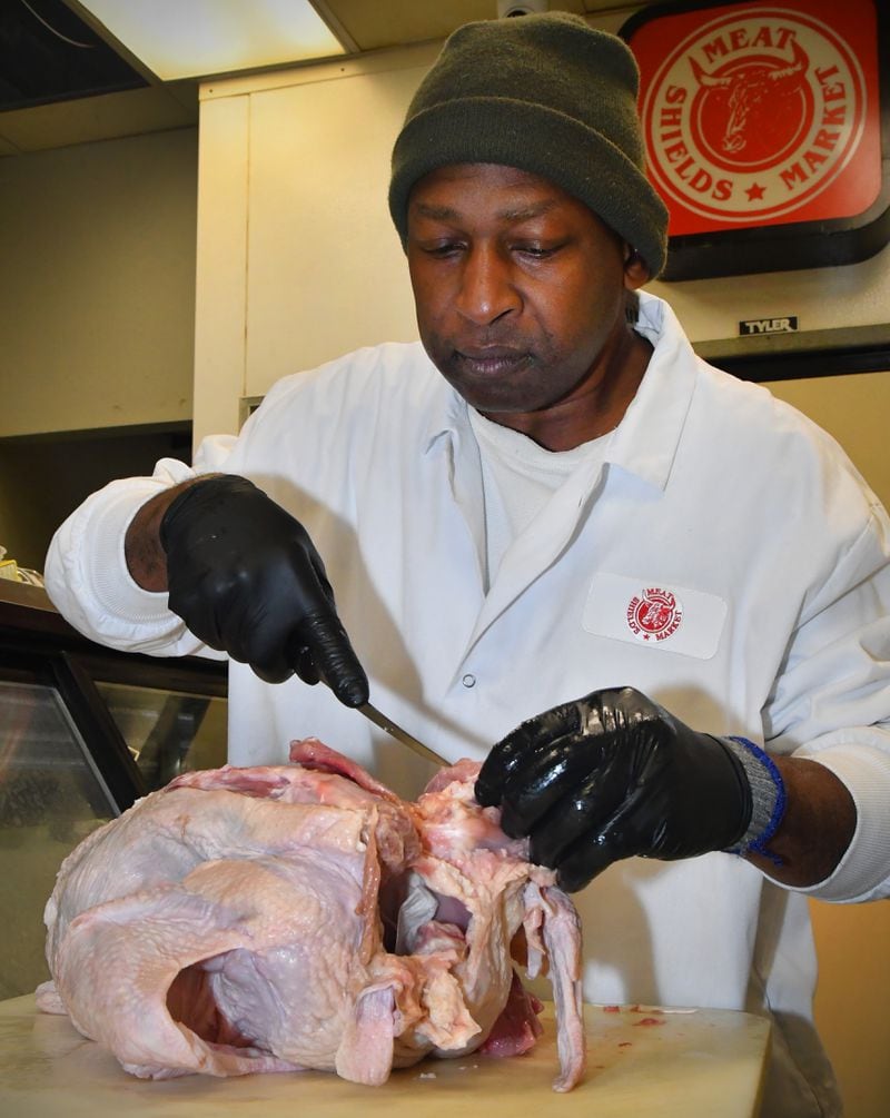 Shield's Meat Market owner Diamond Mardell fulfills a customer's request by deboning a whole turkey. Chris Hunt for The Atlanta Journal-Constitution