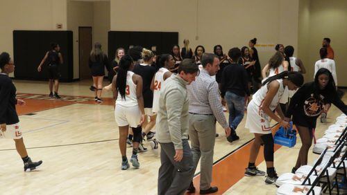Lanier coach Josh Link (front) and the Lady Longhorns exit the court following their 58-54 win over Alpharetta in the opening round of the Class AAAAAA tournament on Friday, Feb. 16, 2018 in Sugar Hill.