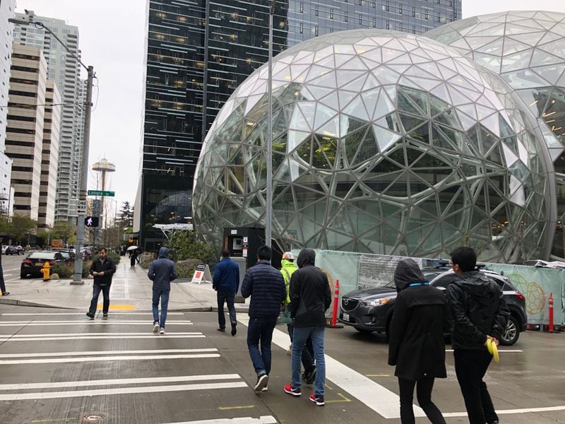 Pedestrians cross the street near the Amazon Spheres in downtown Seattle in April 2018. Amazon has said more than half of its workers in Seattle walk, bike or take transit to work. J. SCOTT TRUBEY/STRUBEY@AJC.COM.