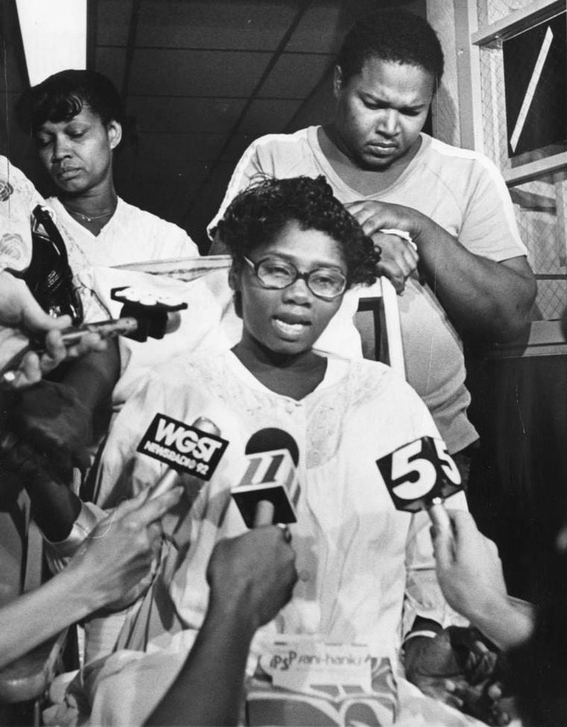 Sandra Alexander, mother of kidnapped child Shanta Alexander, answers reporters questions hoping for the return of her child, Aug. 4, 1981. Father Bobby Alexander stands behind her. Sandra Alexander asked a woman to watch baby while she went down hall. (Billy Downs / AJC Archive at GSU Library AJCP339-175b)