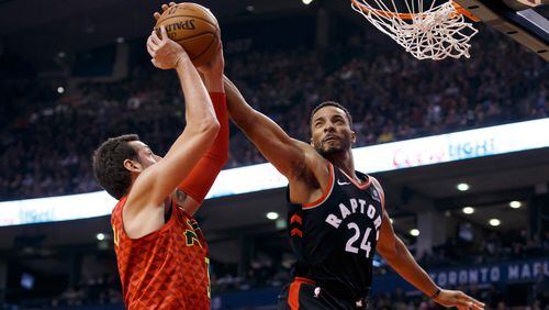 Toronto Raptors forward Norman Powell (24) blocks a shot by Atlanta Hawks guard Marco Belinelli (3) during the first half of an NBA basketball game Friday, Dec. 29, 2017, in Toronto. (Cole Burston/The Canadian Press via AP)